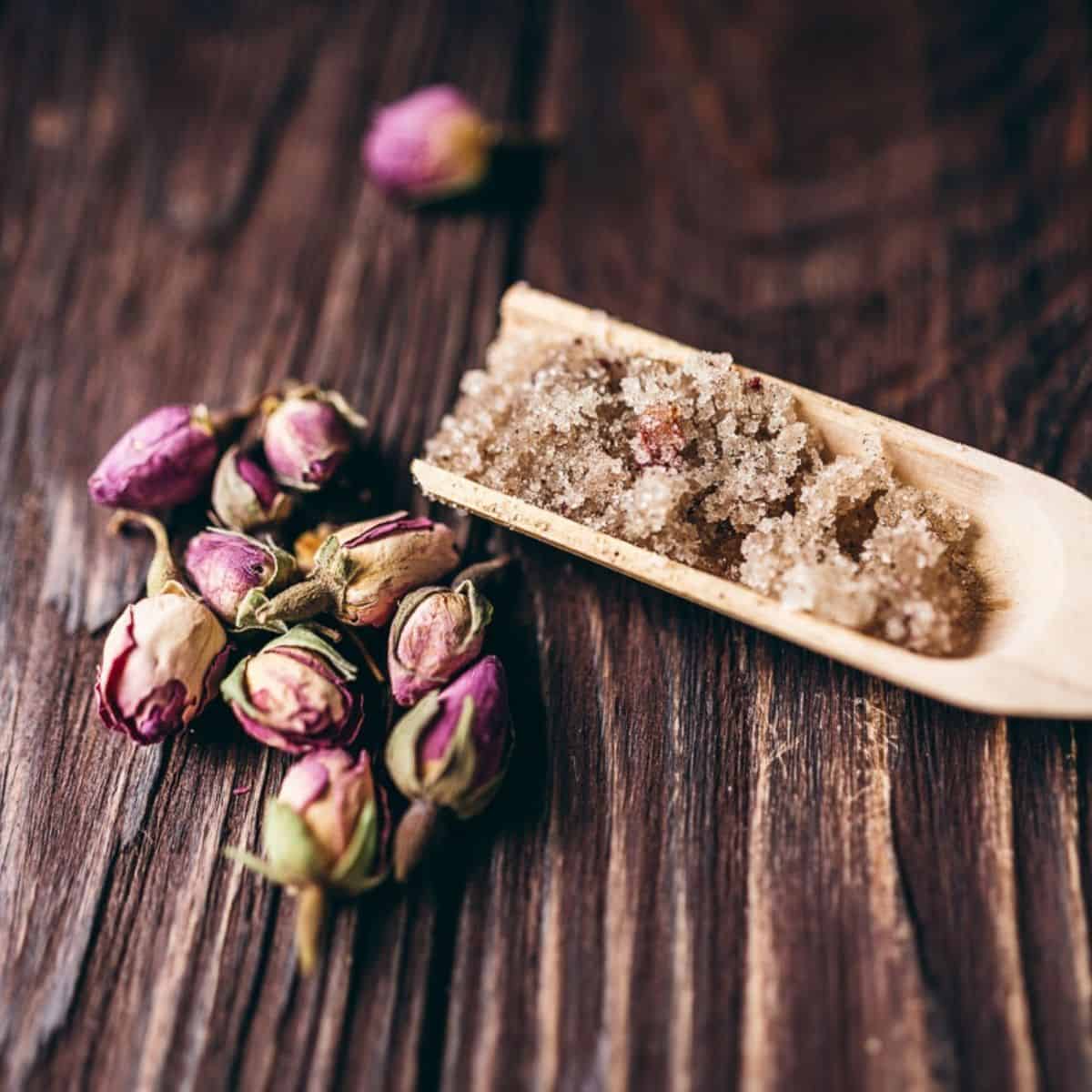 a wooden scoop filled homemade sugar body scrub