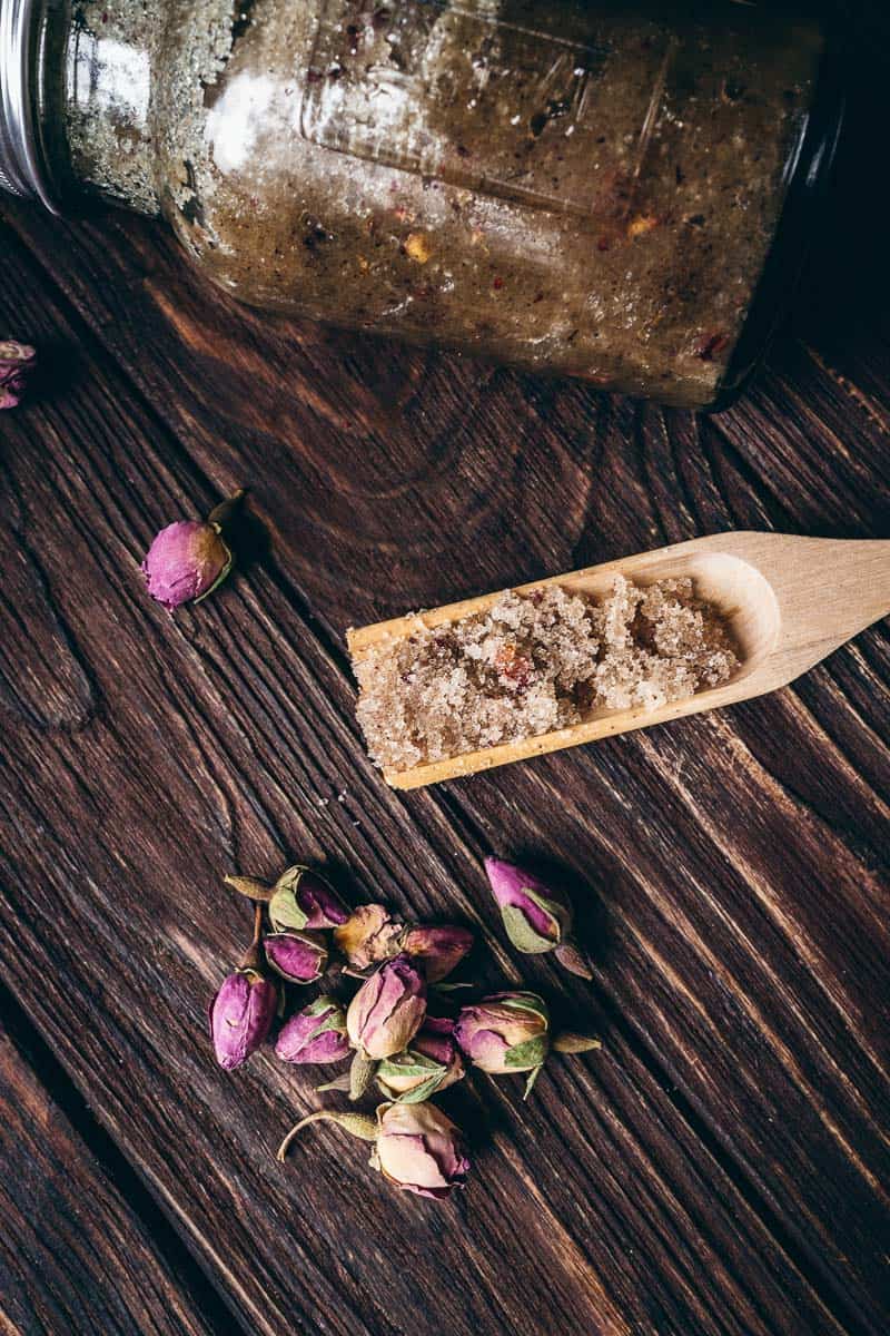 homemade sugar scrub resting in a wooden scoop