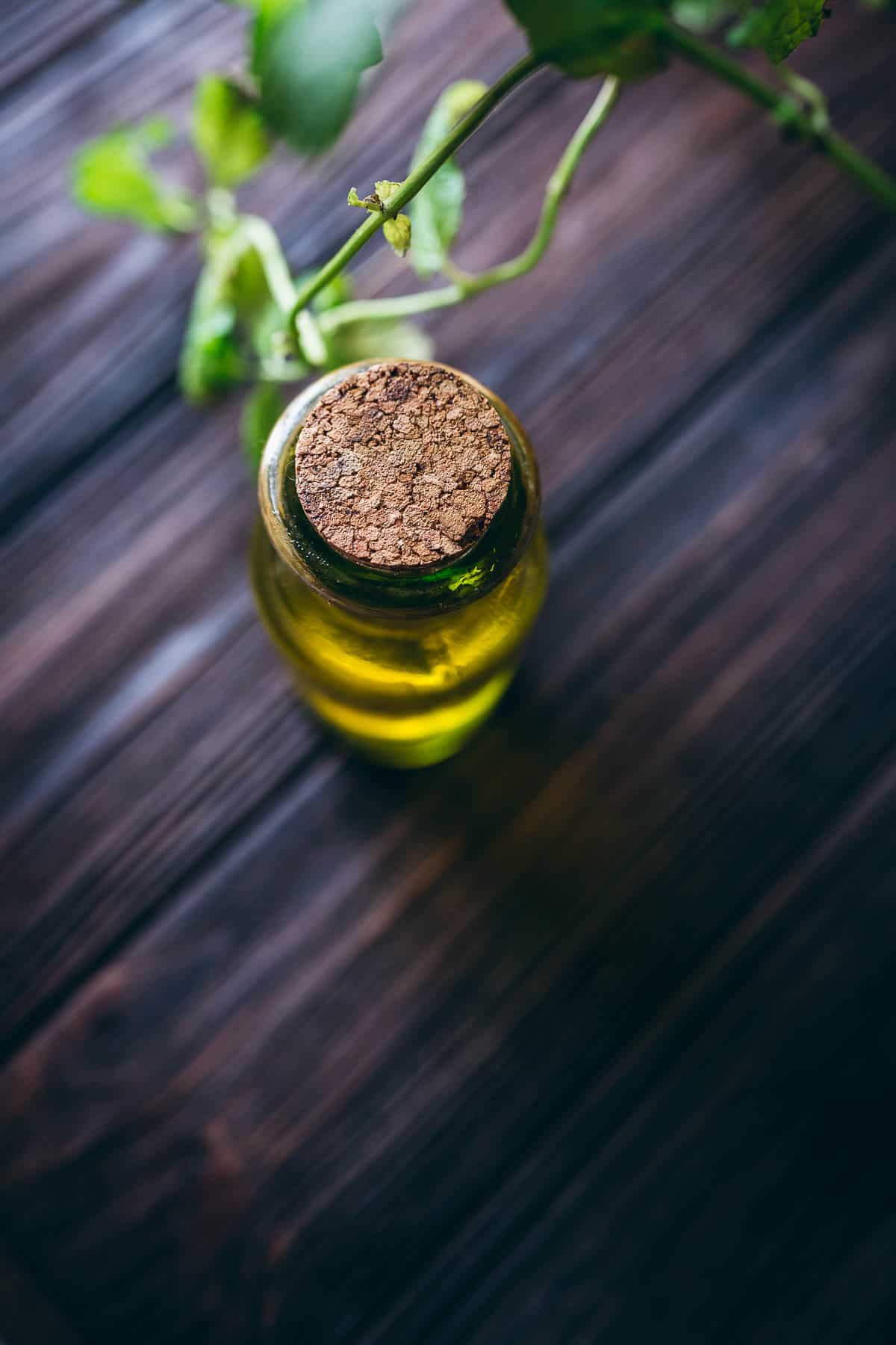 Top view of a corked glass bottle filled with golden liquid.
