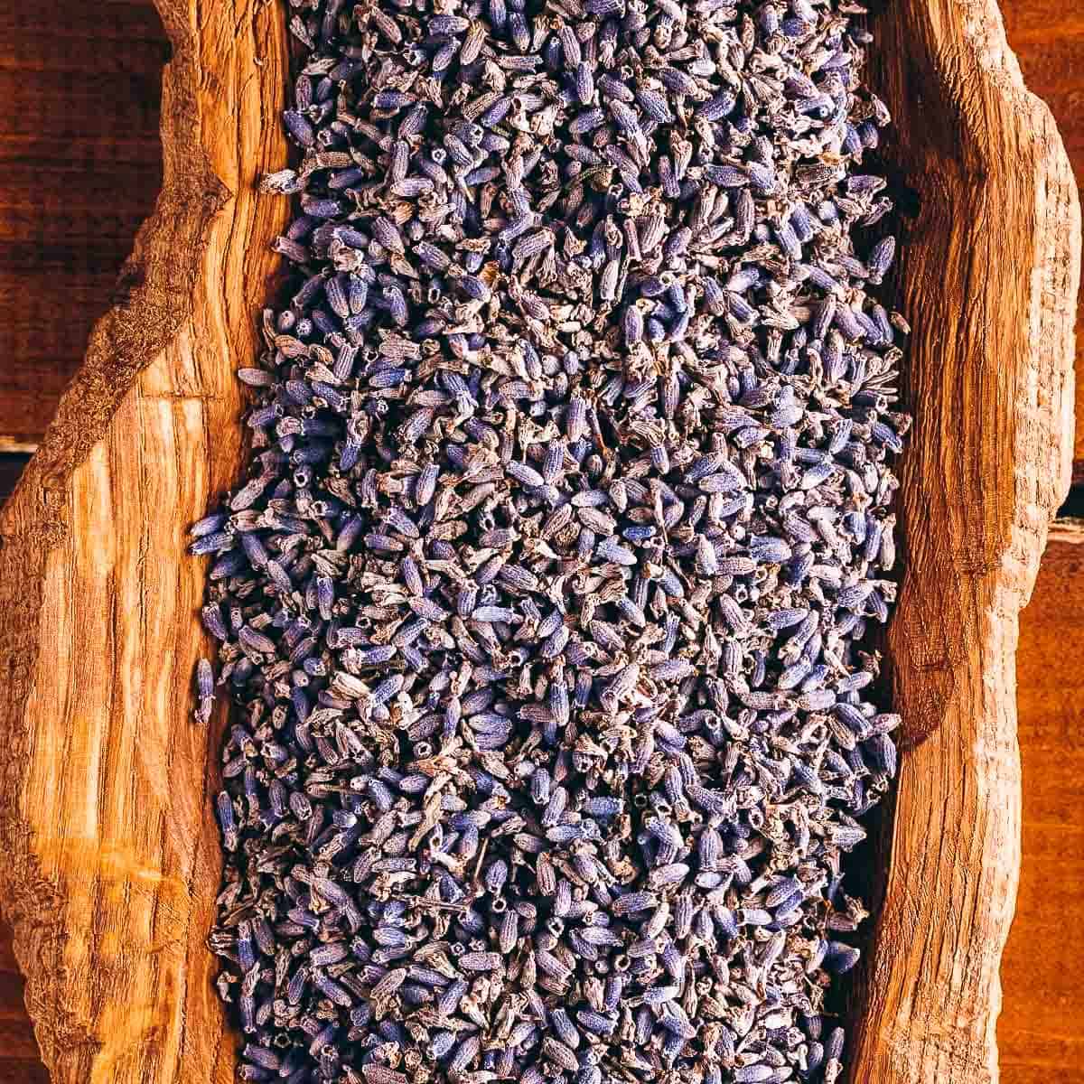 A close shot of dry lavender buds in a wooden bowl.