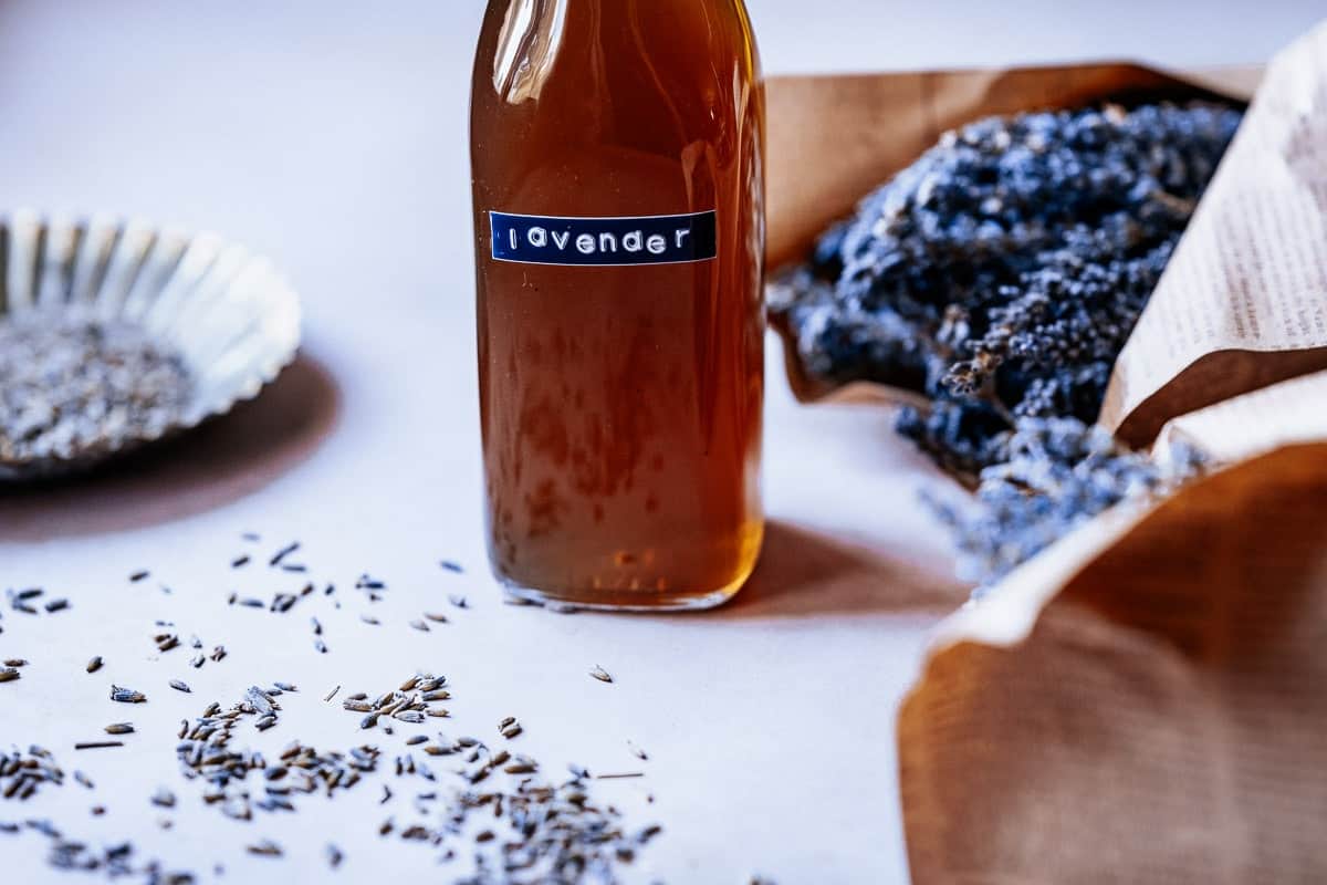 A clear glass bottle with a stick on the front that says lavender.