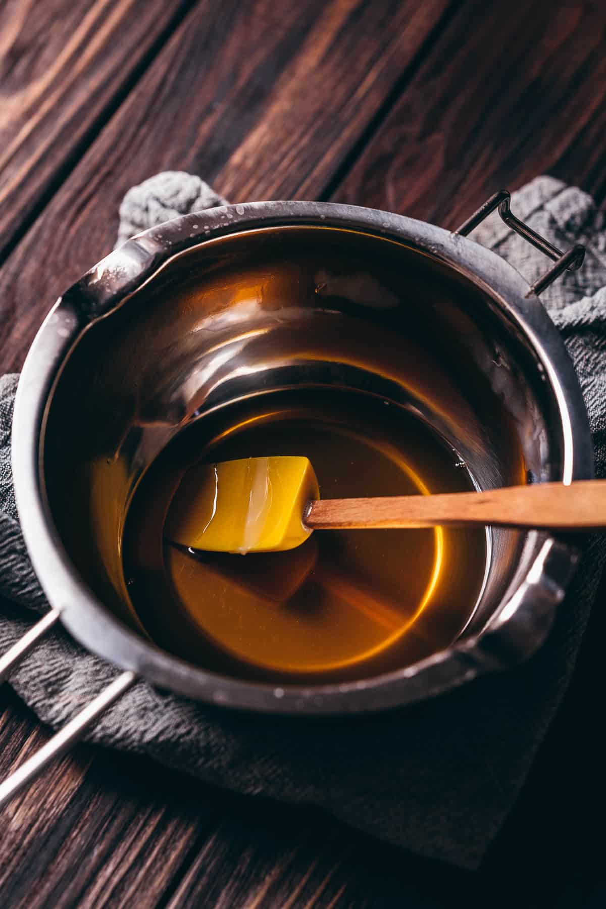 A double boiler pot filled with a golden liquid.