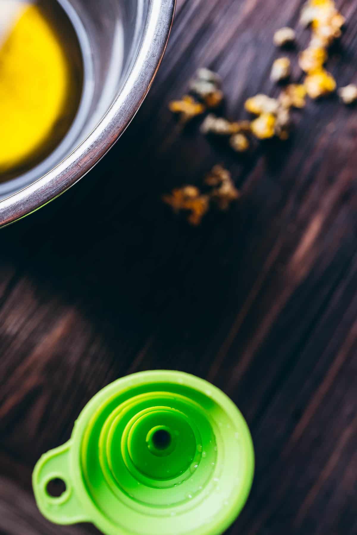 A green silicone funnel rests on a dark table.