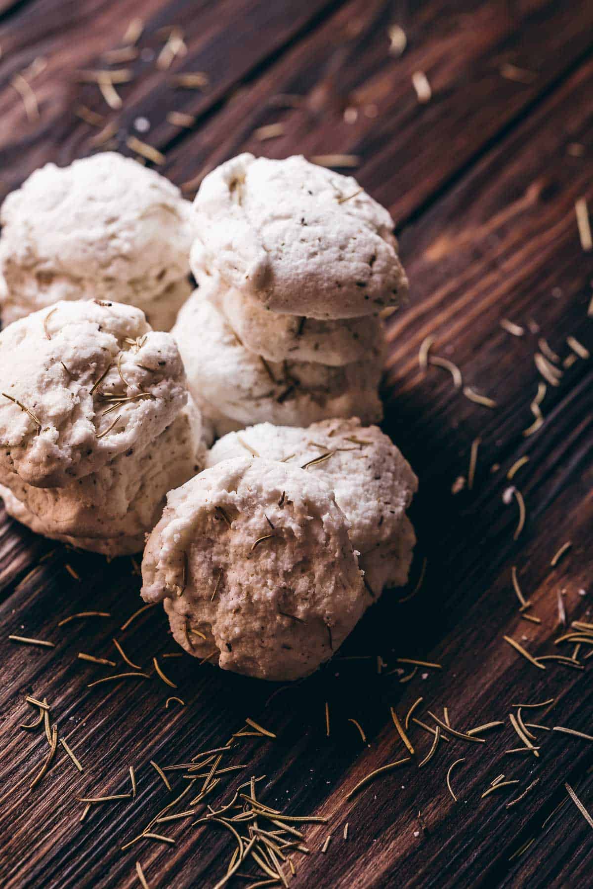 A pile of white bath truffles topped with dried green herbs.