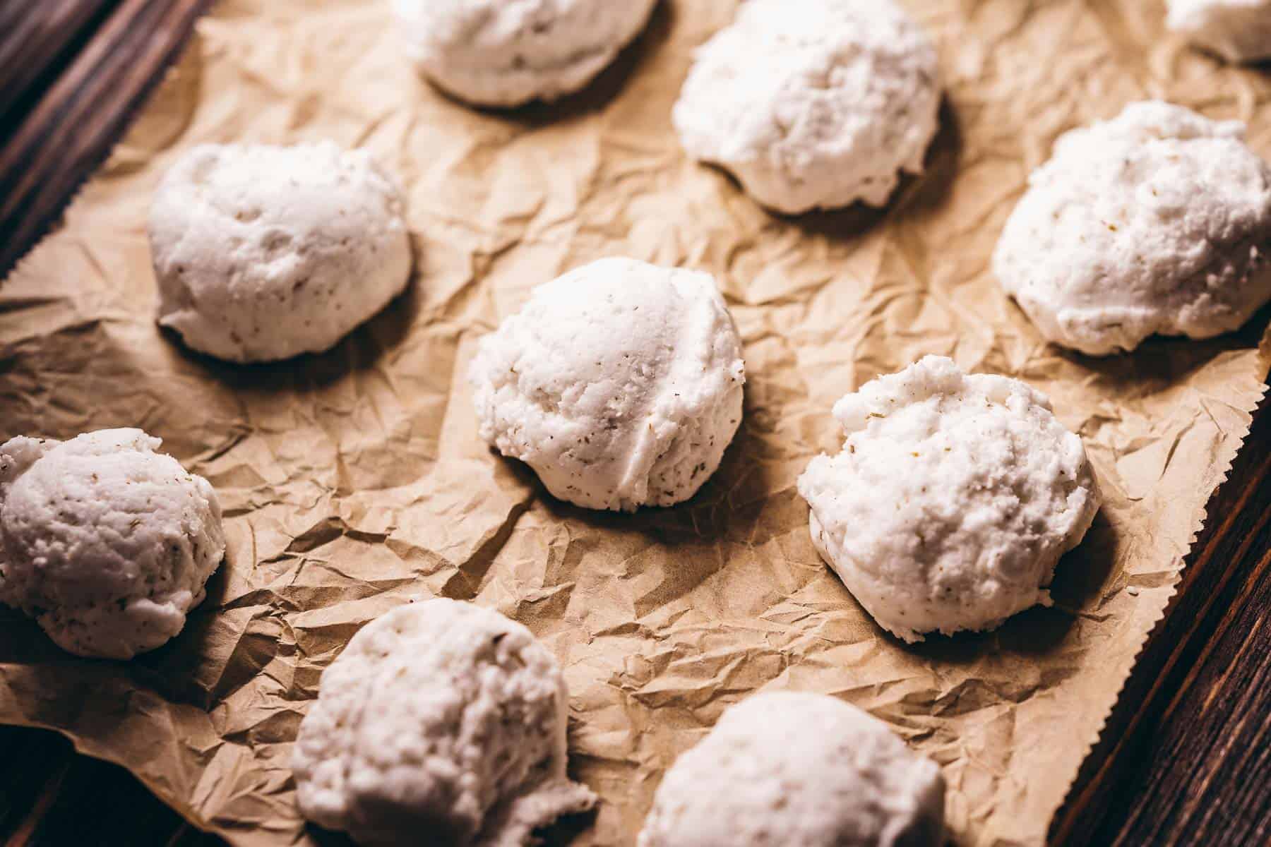 White bath truffles resting on brown parchment paper.