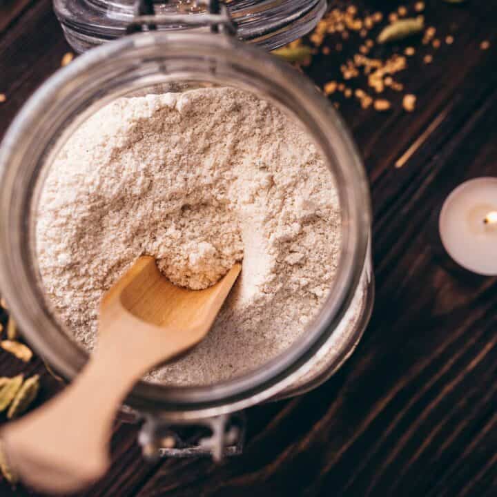 A jar of flour on a wooden table.
