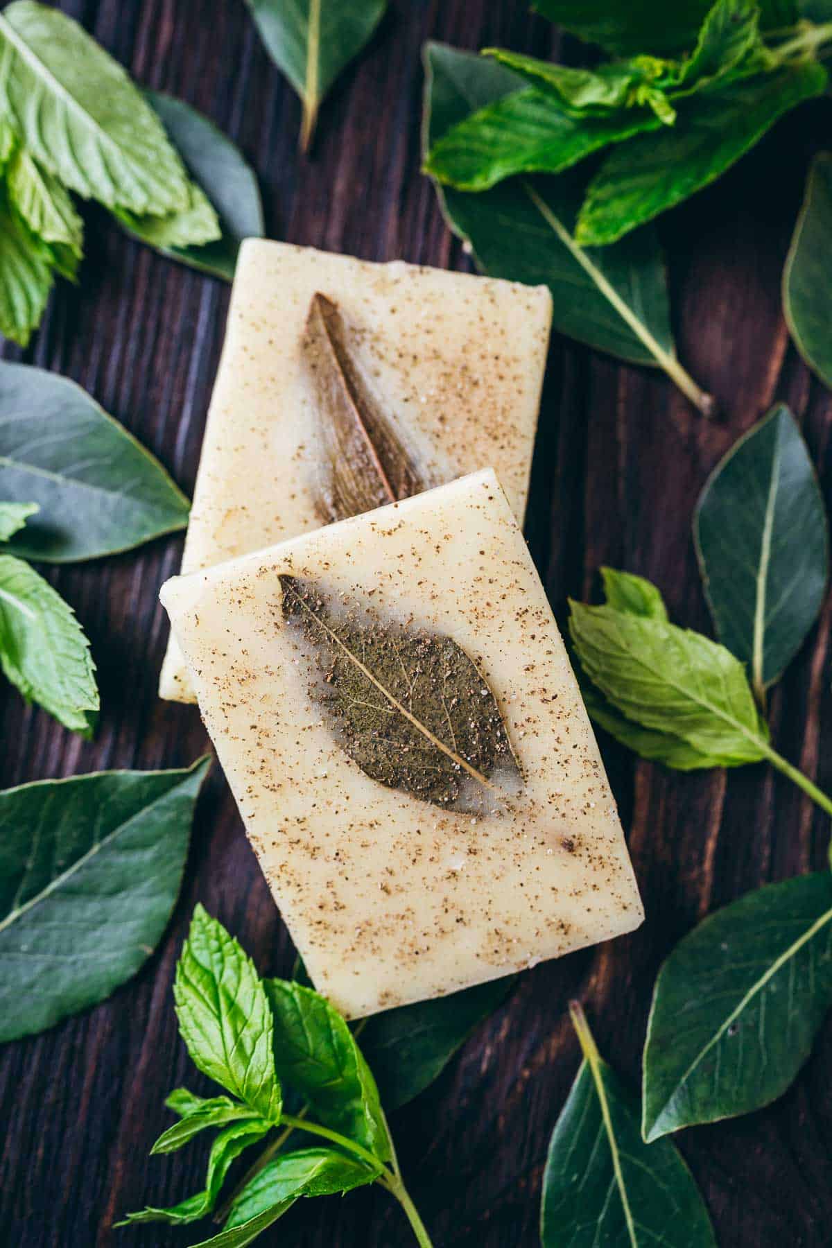 DIY shampoo bars with mint leaves on a wooden table.