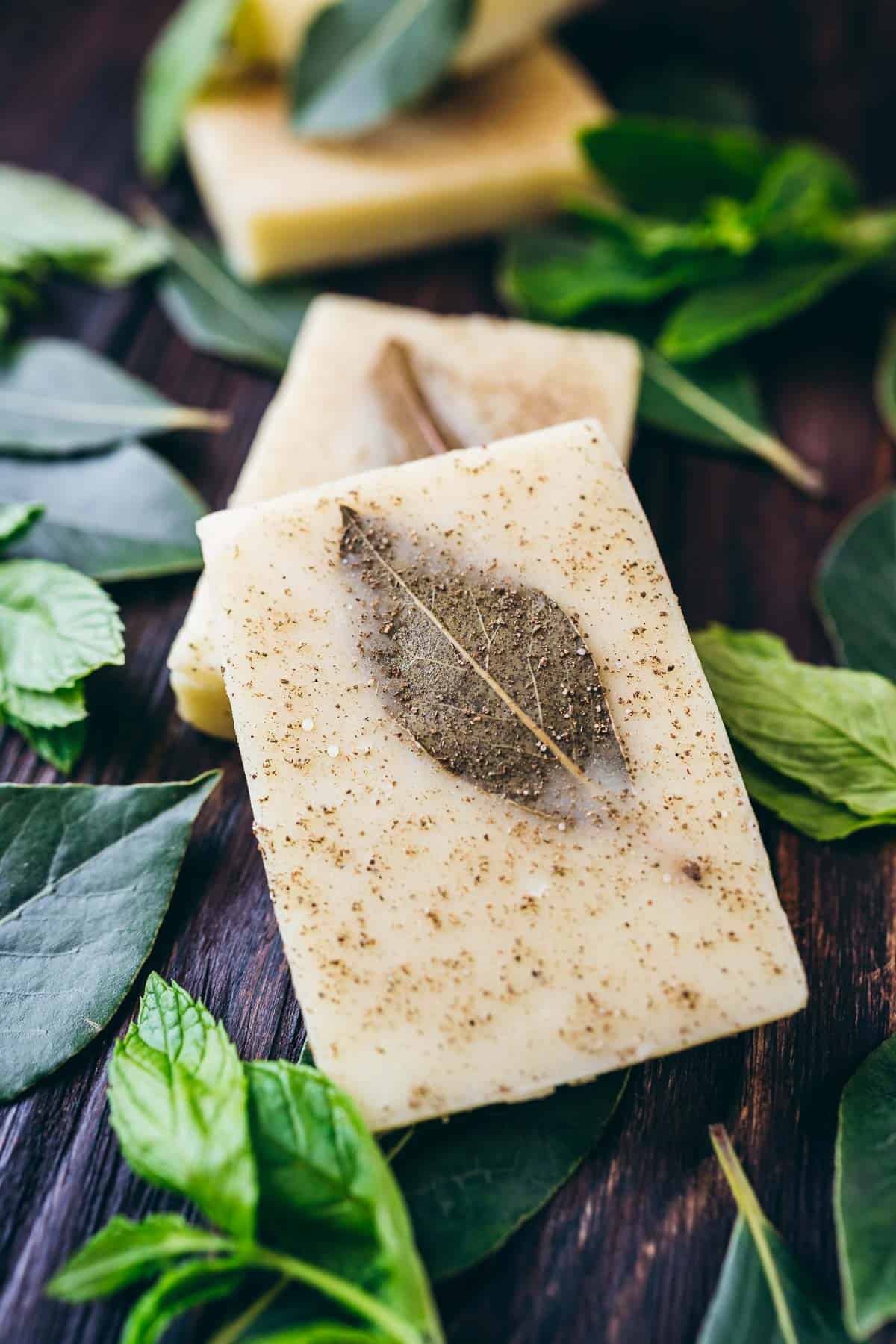 DIY shampoo bars with mint leaves on a wooden table.