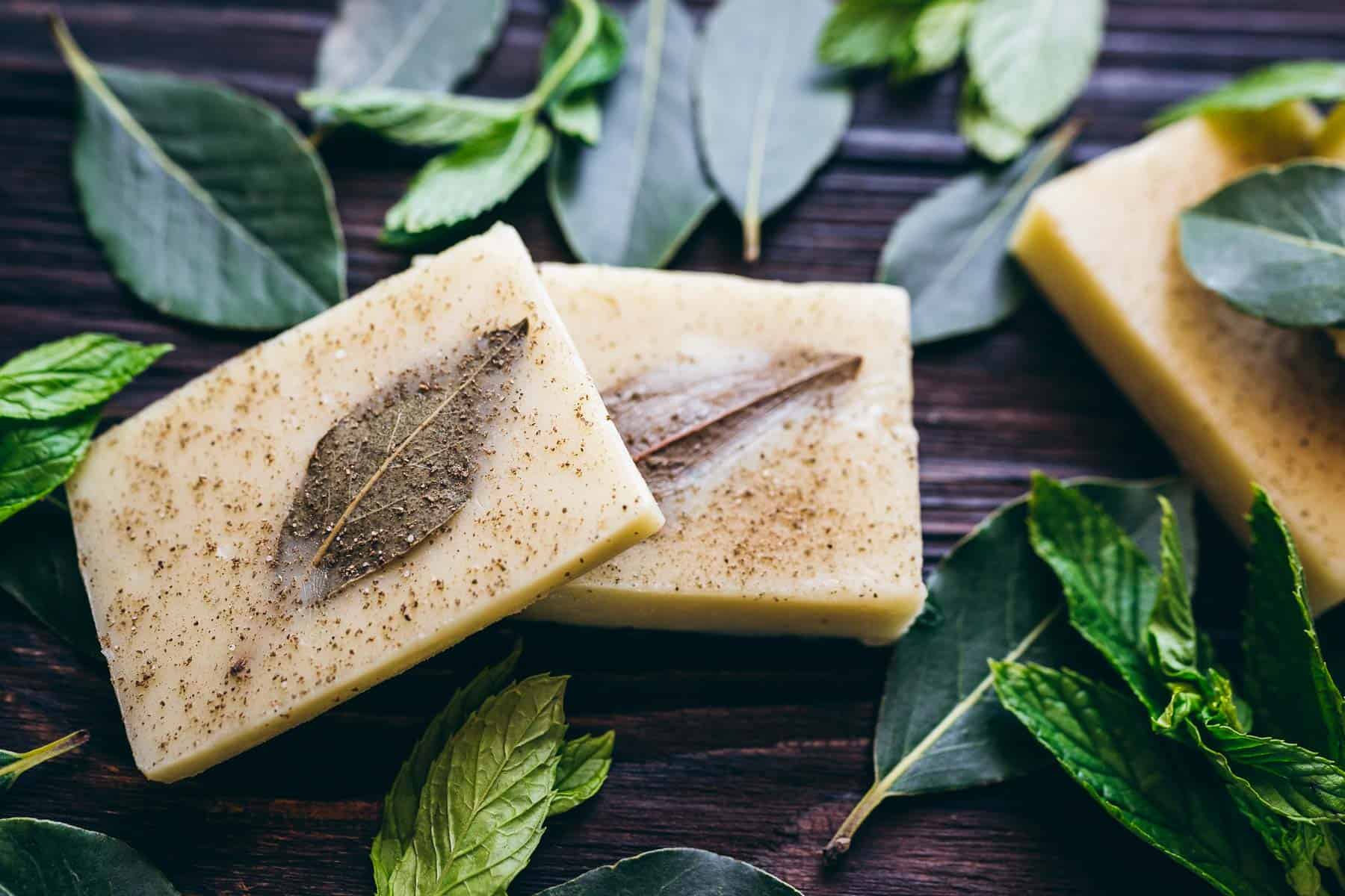 DIY shampoo bars with mint leaves on a wooden table.