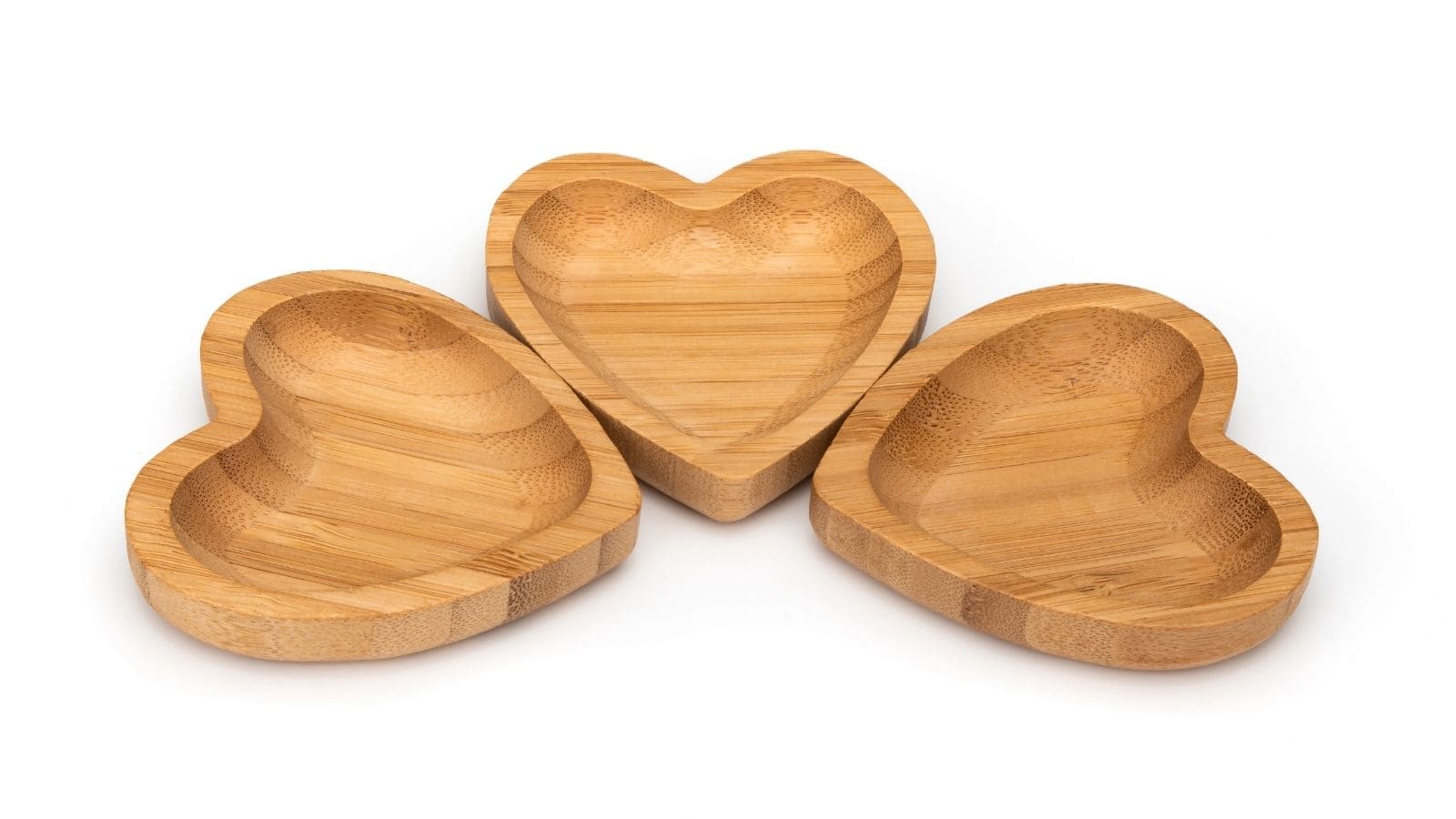 Three heart-shaped wooden bowls are arranged on a white background.