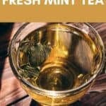 A glass cup of fresh mint tea with vibrant mint leaves rests on a wooden surface. Text above reads: “How to make fresh mint tea.”.