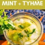 Glass of herbal limeade with honey, mint, and thyme, featuring text overlay reading “HERBAL HONEY LIMEADE W/ MINT + TYHME.”.